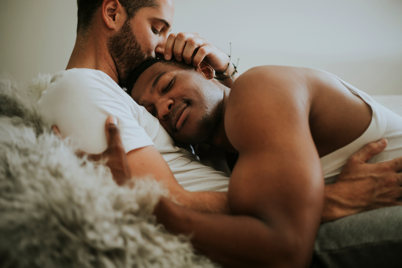 Black gay couple cuddling on bed together. Being in a space with a couples therapist who understands you and your normal life experiences matters. Try marriage counseling and couples therapy with us soon. Find LGBTQ couples counseling near me here!