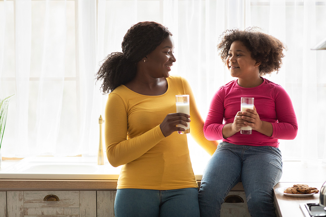 Mom eating cookies and drinking milk with child. Spending time with your child is key, but sometimes we become overwhelmed moms and need help. Begin therapy for moms in detroit, MI or therapy for news mom in order to gain direction.