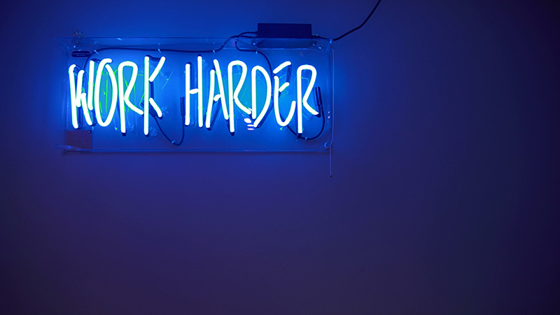 Lit up blue neon sign saying work harder. Its ok to be success and hard working, but overcoming perfectionism as a high achiever can create unhealthy behaviors. Get support with therapy for high achievers in Detroit, MI and begin recovering. Call now for online therapy in Michigan and therapy for men in Detroit, MI!